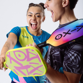 Duo holding AIXO Ghost Prism Break rainbow pickleball paddle — perfect for bold players who love to shine.